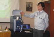 Ацуші Хама демонструє мікроскоп  Hitachi Tabletop Electron Microscope TM3030